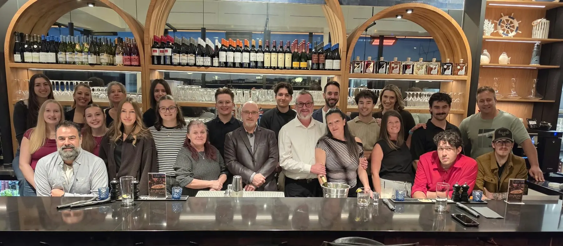 L'équipe du Bistro du Lac réunie au bar, sous les arches