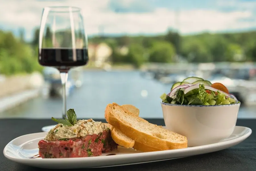 Tartare de bœuf et verre de vin face au lac